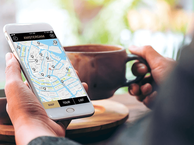 A person holding an iPhone with the Scenic Tailormade app displaye