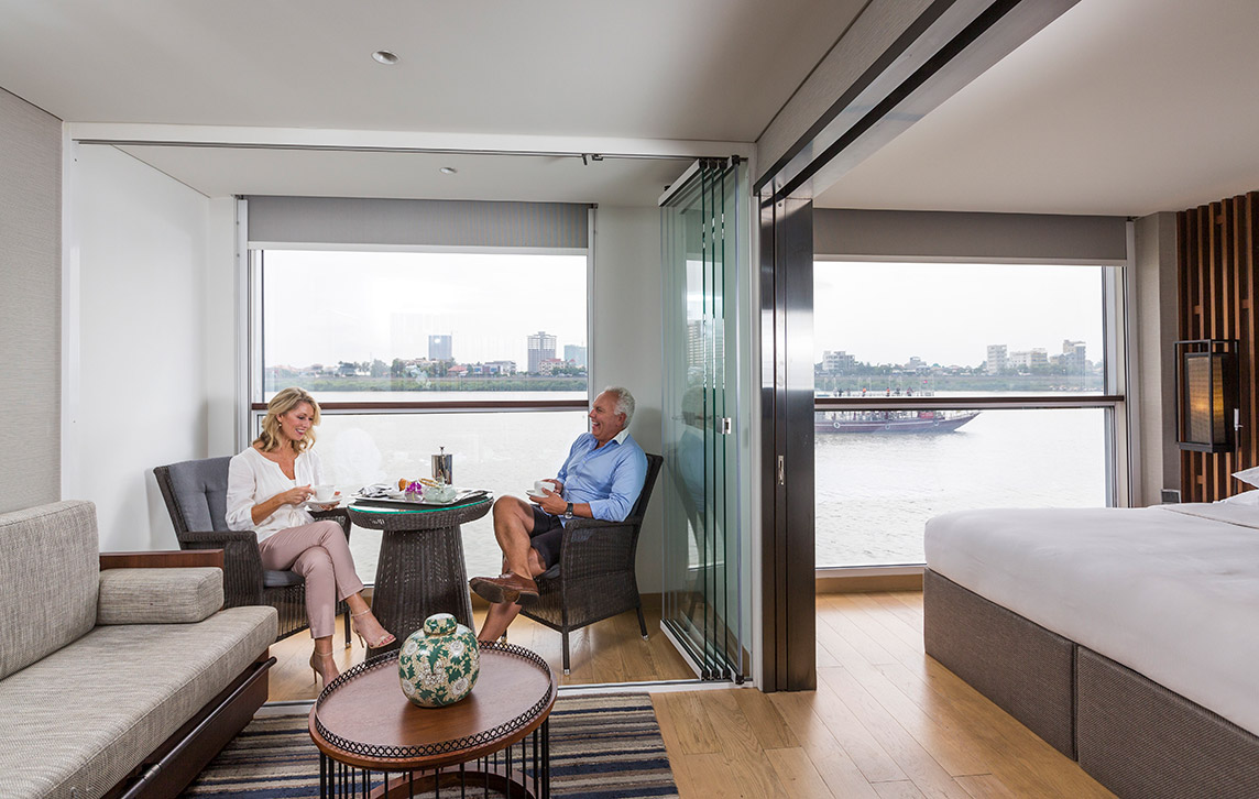 A man and woman having a beverage in the Scenic Sun Lounge area  of the Deluxe Suite