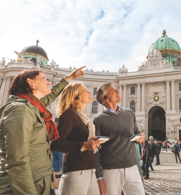 Tourists on a guided tour in front of a historic domed building