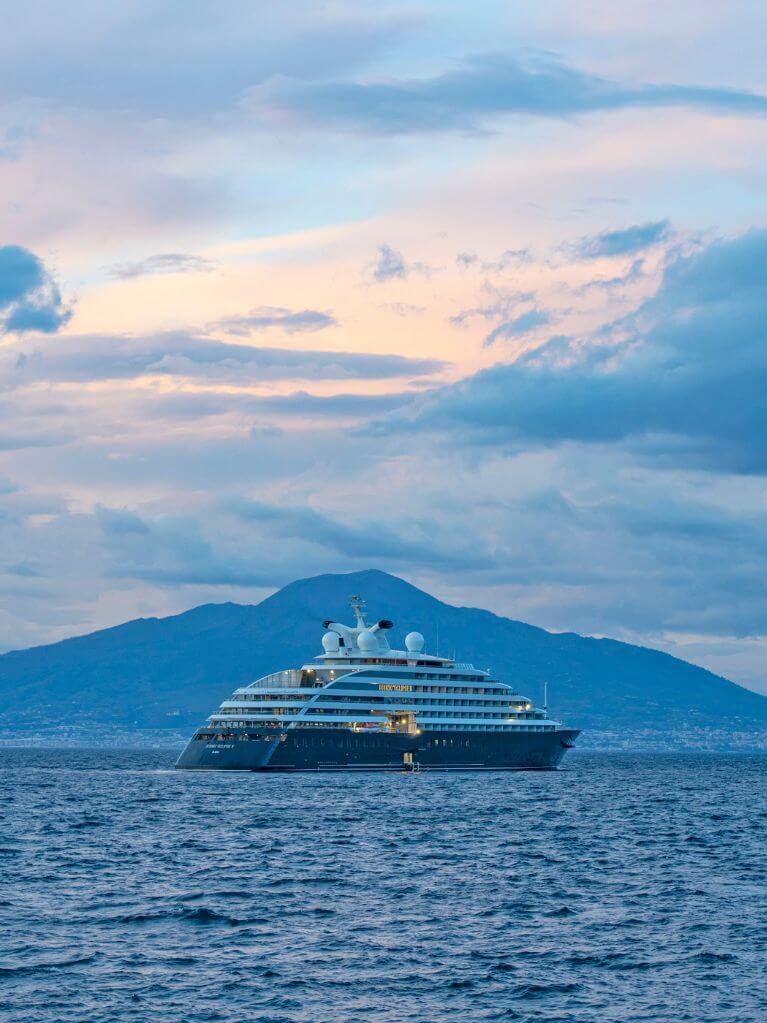 Scenic Eclipse yacht sailing near the coast of Sorrento, Italy, with mountains in the background
