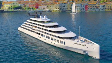 Emerald Kaia floats gracefully on the calm water, reflecting the serene surroundings.