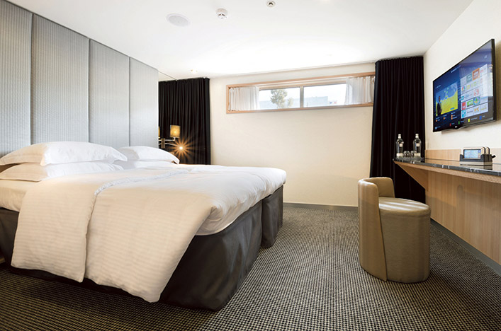 A Standard Suite with a Queen bed and window on the Scenic Gem ship.